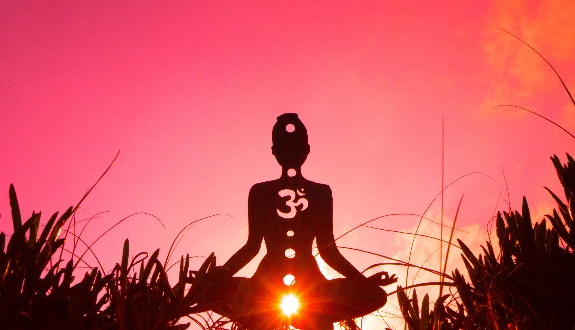 Silhouette of a person doing yoga with the root chakra symbol